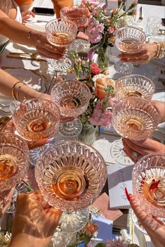 a group of people holding wine glasses over a table