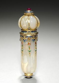 an ornately decorated glass vase with gold trimmings and colorful beads on it