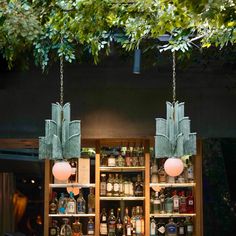 two hanging lights in front of a bar filled with liquor bottles