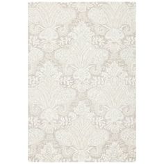 a white rug with an ornate design on it's side and a light gray background