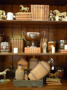 an old book shelf filled with books and figurines on top of wooden shelves