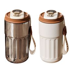 two white and brown trash cans sitting next to each other on top of a white surface