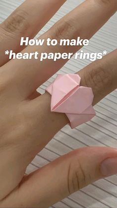 a woman's hand with a pink origami ring on it