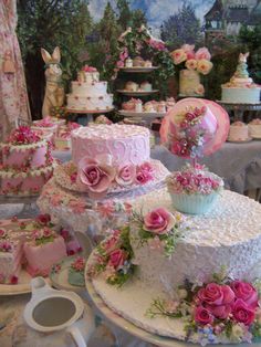 a table topped with lots of cakes and cupcakes on top of each other