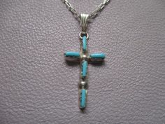 This necklace has a 12.5mm x 23mm sterling silver cross with Zuni turquoise needlepoint stones on an 18" sterling silver elongated box chain with a sterling silver lobster claw clasp. Southwestern Style Silver Cross Necklace, Southwestern Style Silver Cross Necklaces, Southwestern Style Silver Cross Pendant Necklace, Handmade Silver Cross Turquoise Necklace, Silver Turquoise Cross Necklace For Gift, Turquoise Sterling Silver Cross Necklace, Turquoise Cross Necklace In Sterling Silver, Turquoise Cross Sterling Silver Necklace, Turquoise Sterling Silver Cross Pendant Jewelry