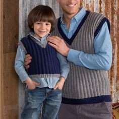 a man standing next to a little boy wearing a sweater vest