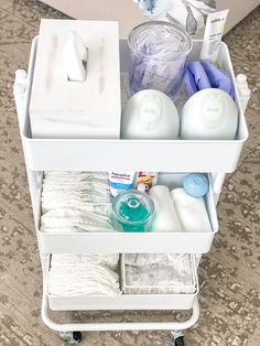 a white cart filled with lots of items on top of a carpeted floor