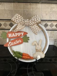 an easter decoration with carrots and bunny ears on the front of a white plate