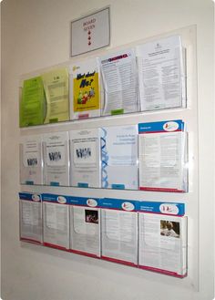 a bulletin board with several different types of papers hanging on it's side wall