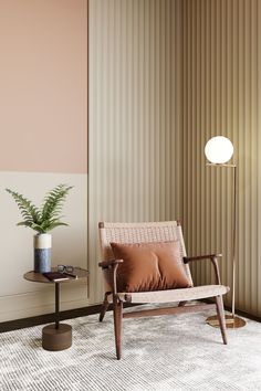 a living room with a chair, table and lamp on the floor next to a striped wall