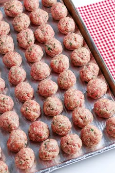 raw meatballs on a baking sheet ready to be cooked