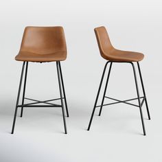 two brown leather stools sitting next to each other