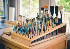 the paint brushes are lined up and ready to be filled with watercolors, pencils, and acrylic paints