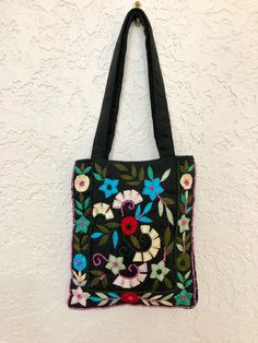 "Super Cute Boho Small Tote/handbag in a black fabric with beautiful hand embroidered and beaded floral pattern. This little bag is in perfect condition. Open tote style, but closes with a small velcro piece. Measures: 6.25\" wide and 7.5\" tall. Handles are 7\" long" Traditional Black Rectangular Shoulder Bag, Traditional Black Rectangular Bag, Black Festival Bag With Floral Embroidery, Traditional Black Tote Shoulder Bag, Black Embroidered Shoulder Bag For Festivals, Traditional Black Tote Bag, Black Beaded Square Shoulder Bag, Black Embroidered Bags For Festivals, Black Shoulder Bag For Everyday Use And Festivals