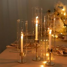 the candles are lit on the table with plates and napkins