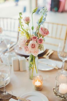 a table set with flowers and candles for a formal dinner or wedding reception at the hotel