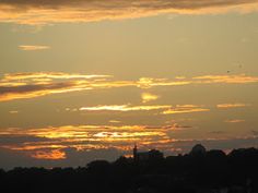 the sun is setting behind some clouds in the sky