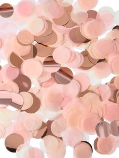 a pile of pink and brown confetti on a white background with lots of circles