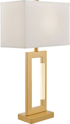 a table lamp with a white shade on the base and a gold frame around it