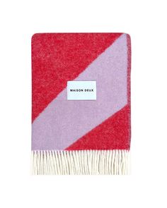 a red and pink blanket with the name maison deux on it's side