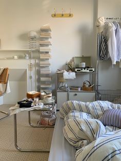 a bed room with a neatly made bed next to a shelf filled with books and other items