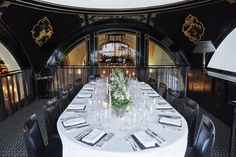 a long table set with silverware and place settings in an ornately decorated dining room