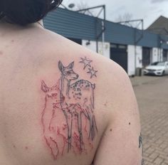 a woman with a deer tattoo on her upper arm and shoulder, standing in front of a building