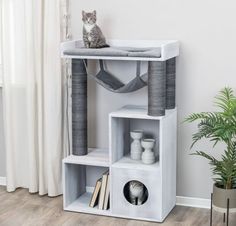 a cat sitting on top of a white shelf