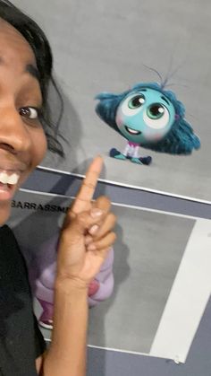 a woman pointing at a cartoon character with her finger in front of her face,