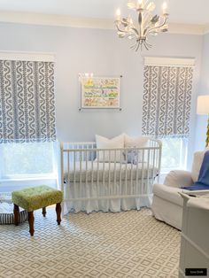 a baby's room with a crib, chair, and window in it