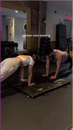 two people doing push ups on exercise mats