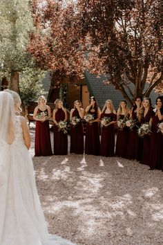 a bride and her bridal party in front of a tree