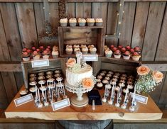 a table topped with lots of cupcakes covered in frosting and orange flowers