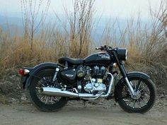 a motorcycle parked on the side of a dirt road