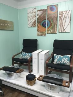 two chairs sitting on top of a white table in a room with paintings above them