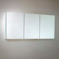 a bathroom mirror mounted to the side of a wall