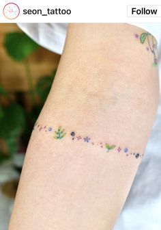 a woman's arm with small tattoos on it and flowers all over the arm