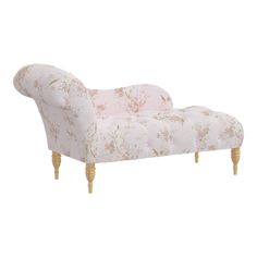 an upholstered chaise lounger with pink floral fabric and wooden legs, on a white background