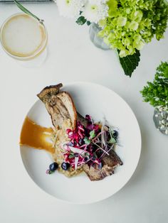 a white plate topped with meat and vegetables