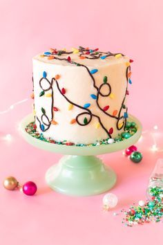 a white cake sitting on top of a table next to confetti and sprinkles