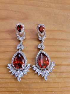 The earrings have a one carat tear drop cut red crystal with a 7 carat red pear cut crystal drop.  Zircon accents.  925 solid silver electroplated. Red Pear, Ruby Bracelet, Deco Earrings, Cameo Necklace, Art Deco Earrings, Genoa, Red Crystals, Crystal Drop, Floral Earrings