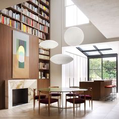 a dining room table surrounded by chairs and bookshelves