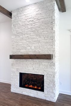 a white brick fireplace with wood mantle and mantel