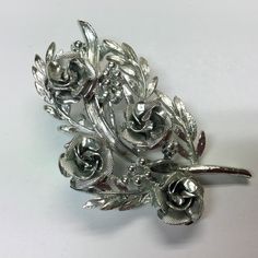 "Signed Coro textured silver color metal brooch. The brooch has roses, leaves, stems and buds. All of them are textured differently which gives depth to the brooch. Measures 2.5\" x 1.5\". Excellent vintage condition." Vintage Silver Flower Pins, Sunflower Themed Kitchen, Perfume Necklace, Metal Brooch, Roses Bouquet, Des Roses, Yellow Heart, Vintage Perfume Bottles, Shawl Pins