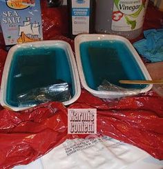 there are two bowls with blue liquid in them on the table next to other items