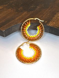 Four colors and four sizes of beads are used to make these unique hoop earrings.  GREAT to accessorize your fall, autumn, Maple Festival, Thanksgiving, Halloween outfit! Approximately 1-1/2" wide and 1-5/8" tall. Not intended for children ages 13 and under.   Also, for many items we can accommodate large orders, so please send us a message. Thanksgiving Beaded Earrings, Friend Holiday, Unique Hoop Earrings, Halloween Outfit, Beaded Hoop Earrings, Beaded Hoops, White Beads, Jewelry Earrings Hoops, Hand Beading