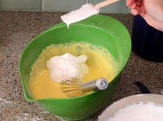 a green bowl filled with batter next to a whisk