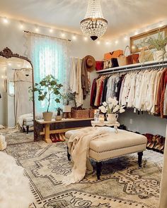 a room filled with lots of clothes and a chandelier