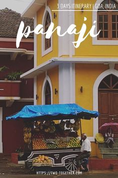 a yellow and white building with a blue awning over it's fruit stand