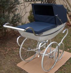 a white and blue baby carriage sitting in the grass